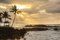 Sunset over waves washing in on the rocks at Uppers Beach Park in Hawaii